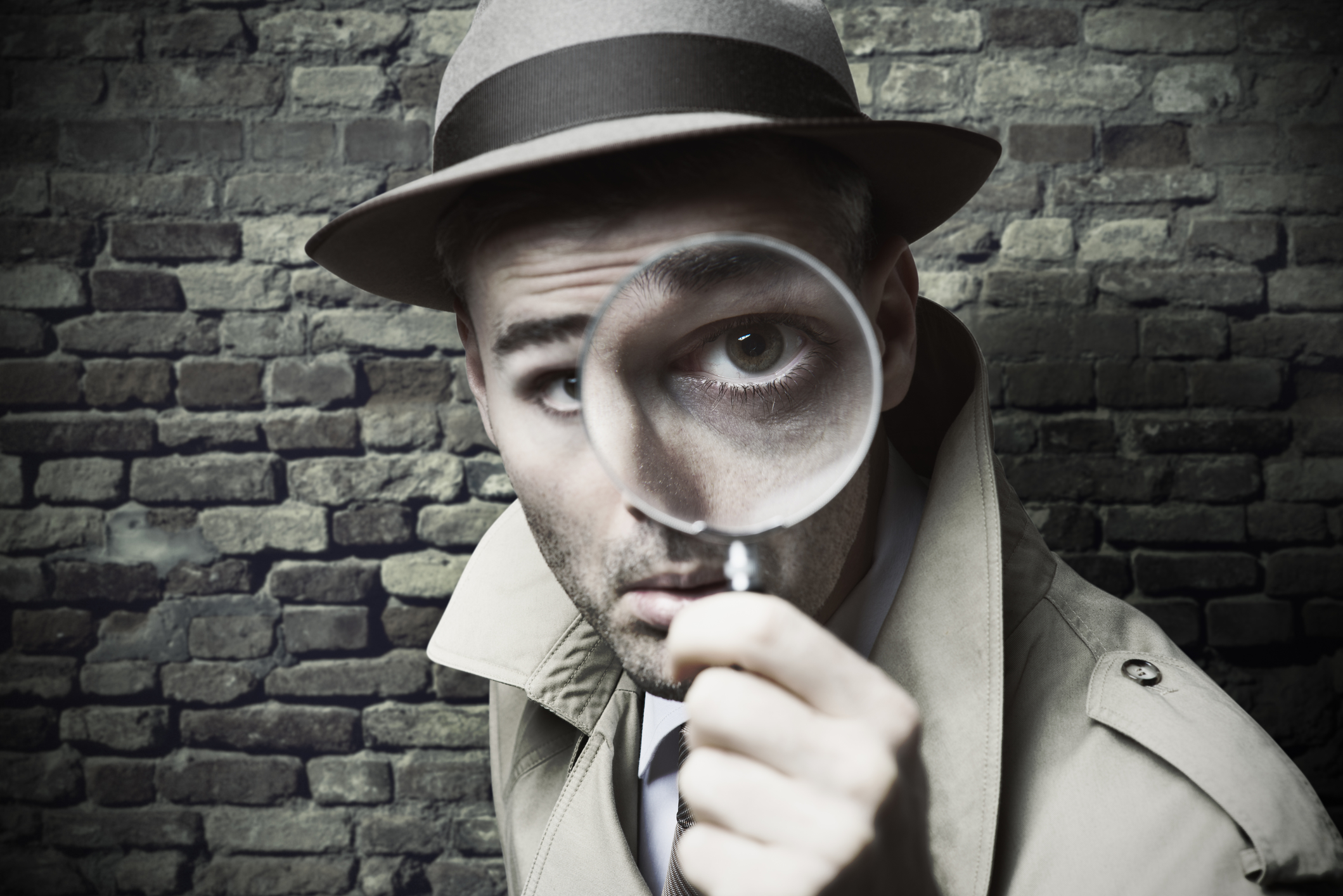 picture of a detective looking through a magnifying glass