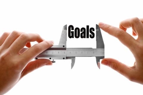 image of hands holding a caliper with the word goals in between