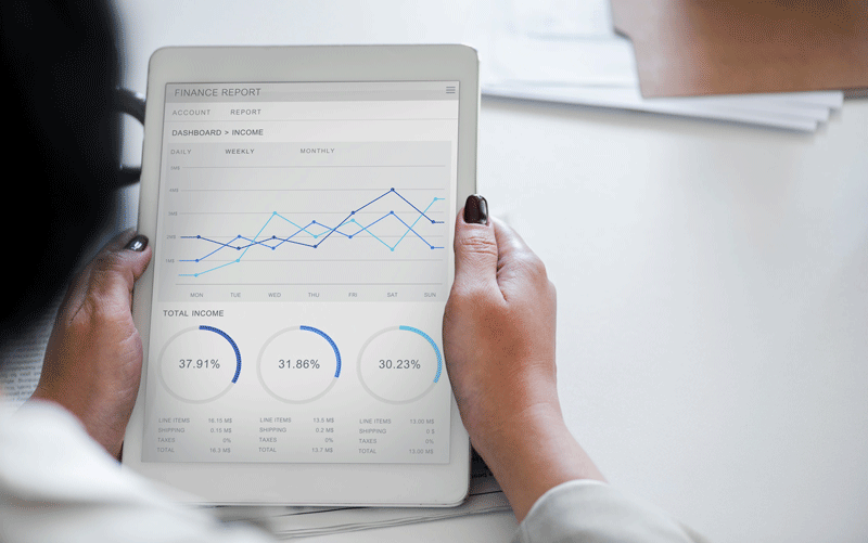 picture of woman looking at iPad with graphs and reports