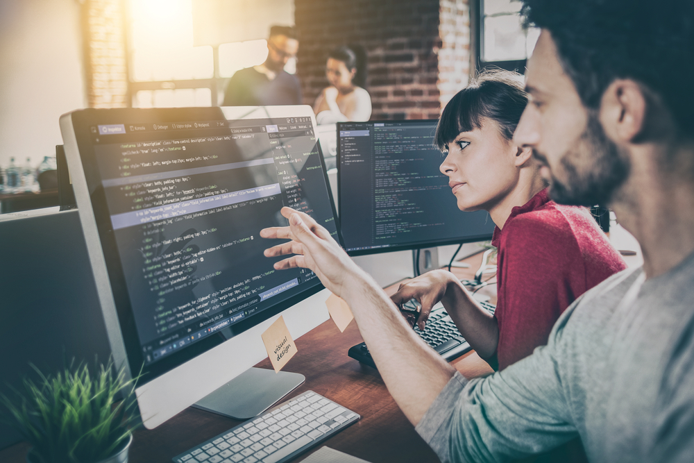 Two software developers at a desk computer